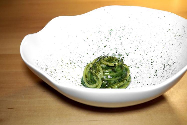 Spaghetto freddo con alghe e zenzero. Lo spaghetto - non tiepido, non fresco, proprio freddo, ed è perfetto, con un morso sodo - viene cotto in brodo di verdure preparato con la pentola a pressione e con sedano, carote, cipolla, porro, funghi e finocchio. Si soffrigge lo zenzero con olio allo zenzero; poi viene bagnato con aceto di pomodoro maison, vi si aggiunge il brodo di verdure e vi si cuoce lo spaghetto. A condire: olio allo zenzero, alga nori, alga wakame sott’aceto (di shardonnay), purea di prezzemolo. Il tutto viene infine raffreddato a bagnomaria. A nostro giudizio, c'è un poco di eccesso di dolcezza, mentre il piatto si presterebbe perfettamente a sciorinare note salmastre e/o vegetali e/o amare e/o acide