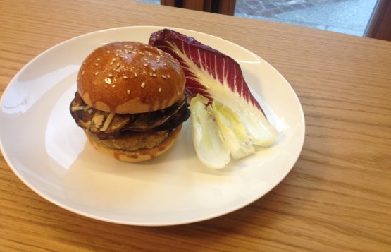 L'Hamburger di manzo di Redzepi per il Refettorio: cosparso di pangrattato, farina e uova e servito con melanzane, salsa di pomodoro e verdure miste. Il pane è pan brioche fresco