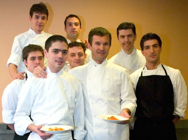 It’s been 12 and a half years since this picture by Alessandro Castiglioni and none of them had a beard then. It happened later. It was the winter of 2005, the year of the first edition of Identità Golose in Milan. Carlo Cracco had Matteo Baronetto beside him, to his left in the photo. They both hold a plate full of Spaghetti with marinated egg yolk, one of their signature dishes. Behind them, on the left, four collaborators of what was then Cracco-Peck, and right, Fabio Pisani with the black apron as well as Andrea Berton
