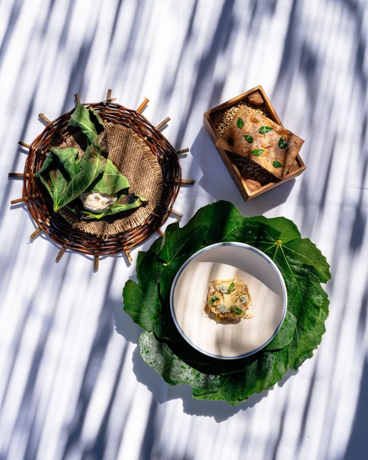 Rossetti cotti al vapore e finiti alla brace in foglie di fico, che proteggono e rilasciano note aromatiche, conditi con un pebre di pomodori (ricetta presa dal Cile) e crackers cotti alla brace, profumati con origano fresco dell’orto. Il risultato? Tra una bruschetta e una panzanella di mare