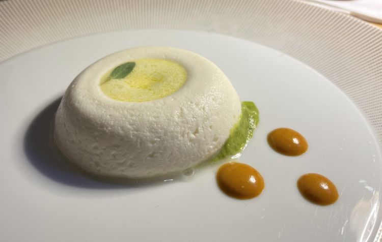 Savarin di caprino, schiuma di olio extravergine d’oliva, zucchine e riccio di mare
«Questo è un piatto storico che ho quasi sempre in carta nel mio ristorante: alla base c'è il composto, morbido e tiepido, con cui formo la ciambellina che cita la creazione di Brillat-Savarin. A volte lo preparo con un pecorino, a volte come in questo caso con il caprino. Poi il piatto lo modifico in base alla stagione, a volte con un gusto di Carbonara, con guanciale e uovo, questa volta con zucchine e ricci di mare»
