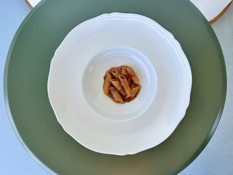 Penne, acqua di pomodoro e olive nere: sono penne mantecate in acqua di pomodoro, olive nere e cotte in forno. La pasta è lasciata molto al dente: questo impatto in bocca è importante. Poi arriva tutto l’amaro dell’oliva