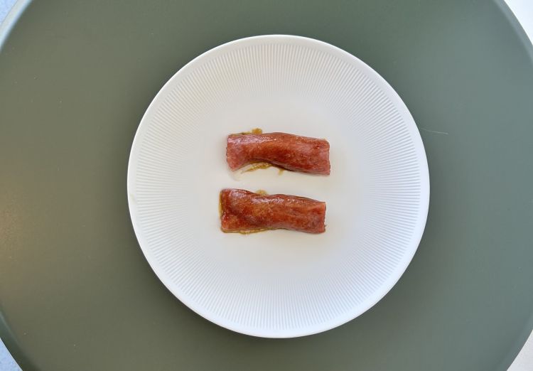 Piccione e ventresca di tonno rosso: il piccione, interpretato in maniera diversa. Viene prima cotto leggermente a vapore e poi sezionato in due. Sopra un po’ di pâté di fegatini di piccione e una punta leggera di wasabi; poi ventresca di tonno rosso e fondo di piccione. A lato, un brodo freddo di alghe e tartufo nero