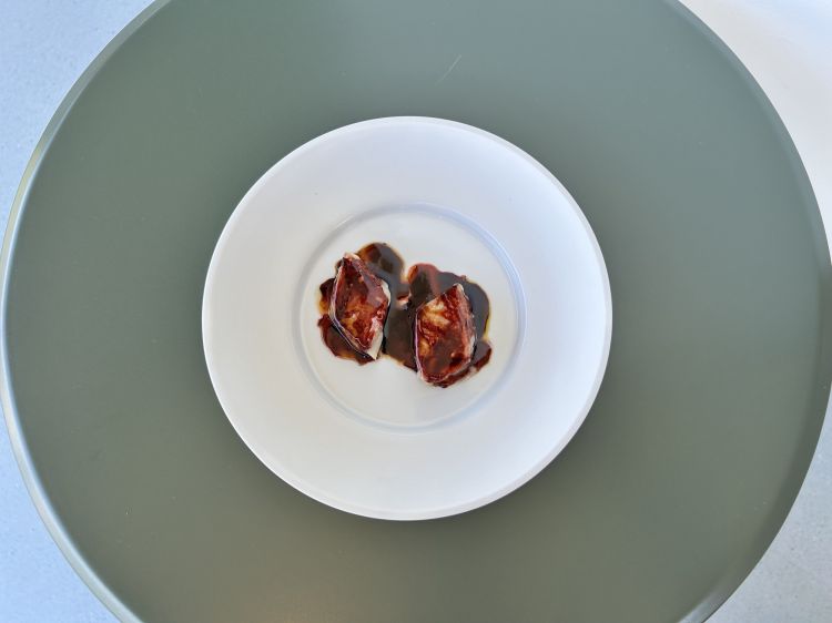 Triglia, prugna fermentata e Sangiovese: doppio filetto, per avere una masticazione più importante. Viene cotta molto lentamente a vapore e dentro rimane semicotta. Sotto, prugne fermentate con pepe; sopra, una riduzione di Sangiovese, che richiama naturalmente il territorio. Riducendolo, il vino perde gran parte dell’aromaticità e restano soprattutto tannino e acidità. Poi i profumi sono ricostruiti con essenze ed estratti: pepe, rosa, violetta. La masticazione è incredibile, la triglia tiene a bada le note acide-tanniche-speziate