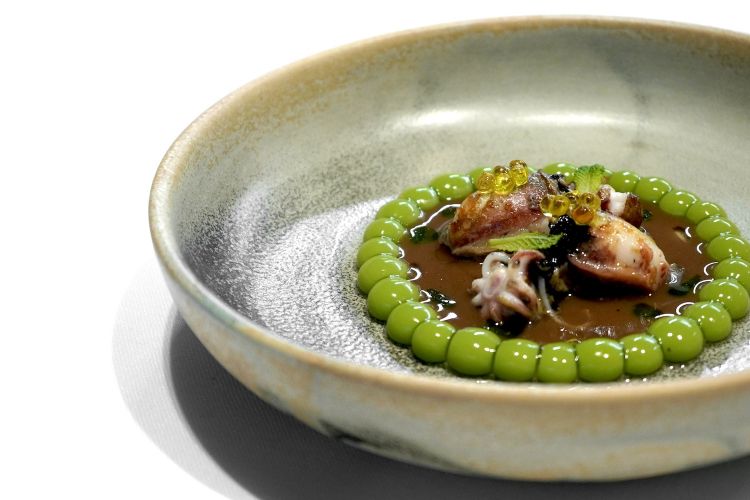 Squid with multispheric Catalan peas: it’s all seasoned with a sauce of botifarra negra, a typical Catalan sausage, made with part of the boiled blood of a pig. The "fake peas" are made with a cream of spherified peas with the multi-sphere technique, that is to say a series of spherifications, stabilised with a gel of glutamate (see the famous Tatin de foie-gras y maíz multiesférico, here)
