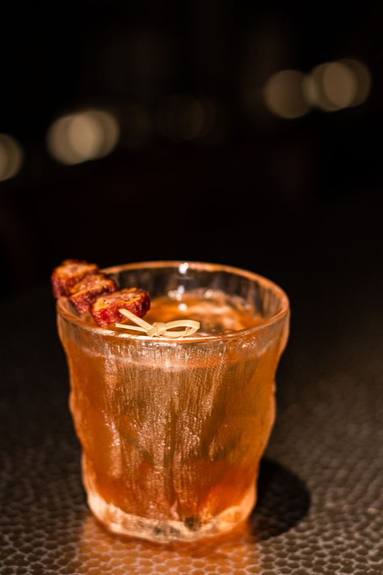 Banana è un drink a base di Bullet Rye Whiskey, calvados, vermouth, campari, foglie di banano grigliate, cumino, banana essiccata e banana verde.