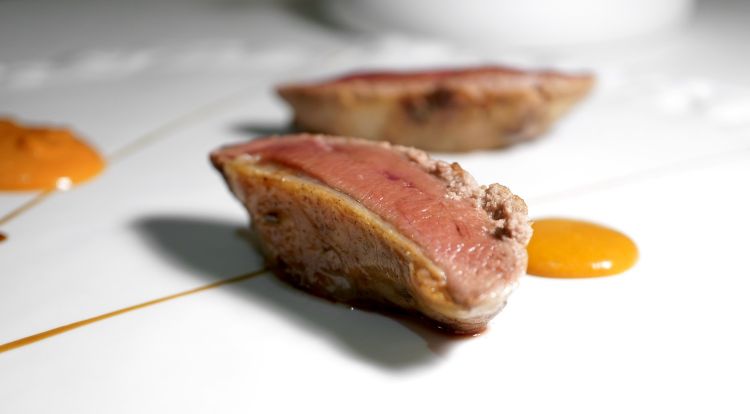 Piccione, salsa Choron, curcuma. Il volatile è di Moncucco, frollato per 5 giorni a 0-2°, la coscia è arrostita e glassata col suo fondo, il petto accompagnato da ciliegie. Ben eseguito