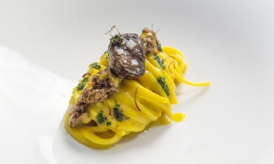 Spaghetto Milano, an emblematic dish at Identità Expo: pasta Felicetti is seasoned with a cream made by blending risotto alla milanese, and then with a bone marrow ragout and finally with a piece of bone marrow