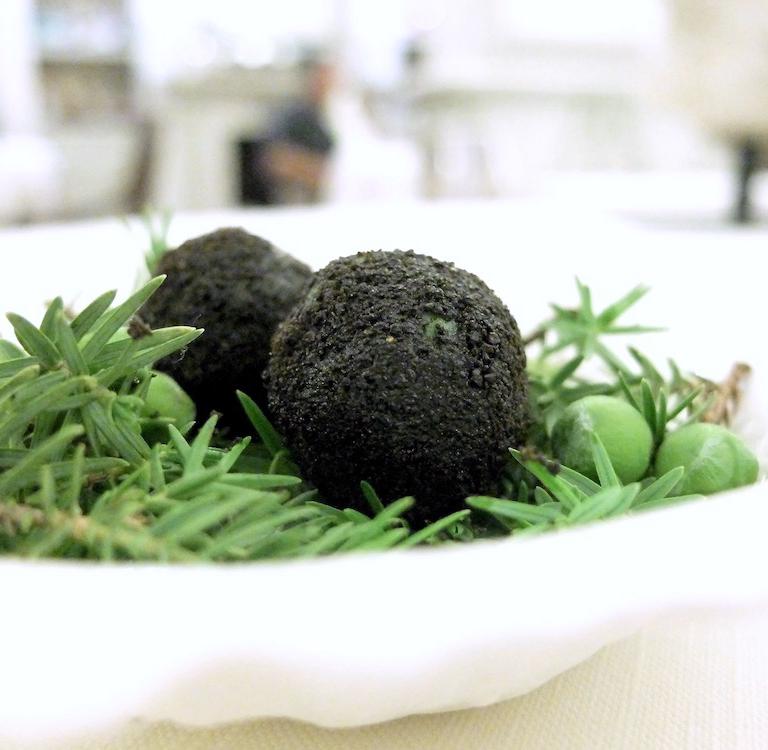 Sfera di pomodoro con acqua di pomodoro fermentata, ricoperta di pesto d'erbe aromatiche