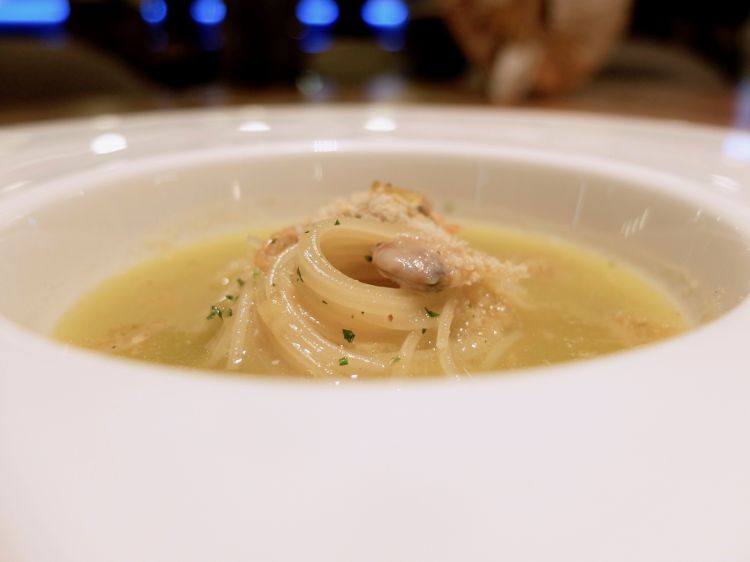 Super, ormai un classico di Alice: superspaghettino con brodo affumicato, julienne di calamaro, vongole, polvere di tarallo e limone. Costante di tutte le portate è il bell'equilibrio tra le componenti gustative
