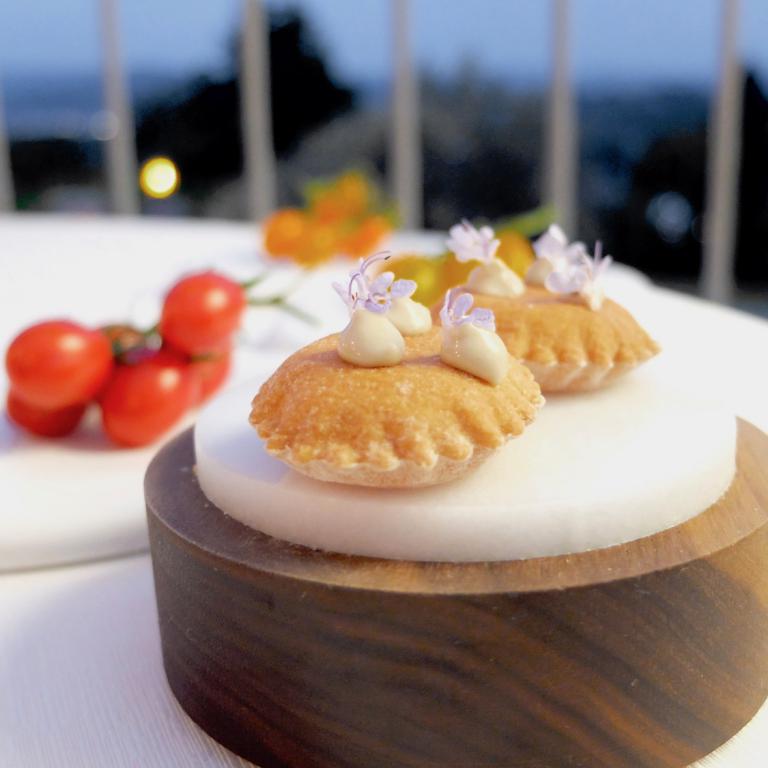 Puffed crackers with cream of anchovies and tomato. You can eat them with three types of tomatoes (in the background), chosen among the 60 available in the vegetable at La Madernassa. In the glass, tomato water with vanilla from Tahiti and rum agricole
