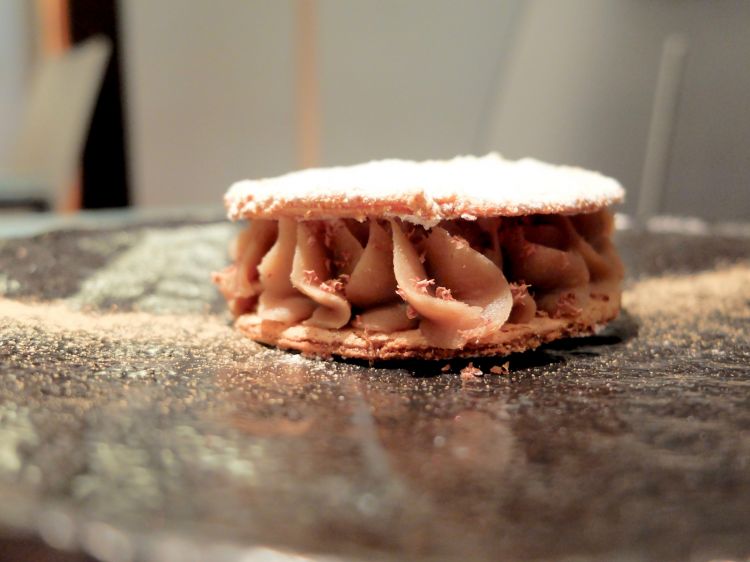 Biscotto croccante alla mandorla, crema di marroni alle spezie scure (ginepro, chiodi di garofano, pepe...), briciole di cioccolato fondente Valrhona Guanaja 70%, panna alla polvere di porcini, polvere di porcini