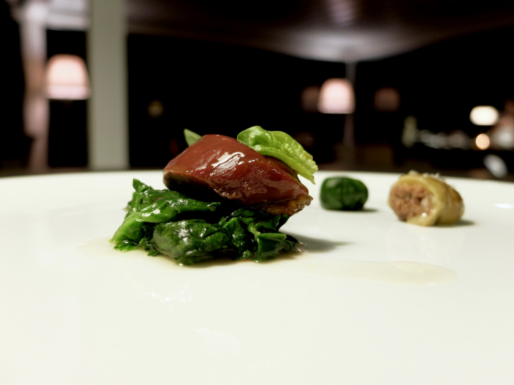 Petto di piccione glassato al polpo e litchi, spinaci allo zenzero. La coscia è brasata, poi un cubetto di tartare di suo filetto crudo avvolto in una foglia di spinacio calda. Grandissima classe