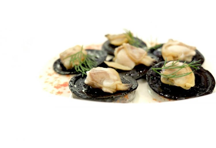 Bottoni al nero, ricci di mare, emulsione di vongole veraci, vongole, limone del nostro giardino, crema prezzemolo e aneto
