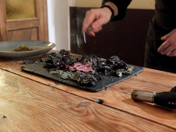 Al tavolo viene scottato un filetto di pecora gigante bergamasca racchiuso in foglie di frassino fermentate
