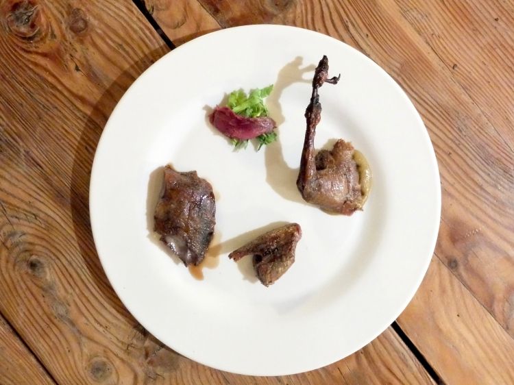 Ed ecco il piatto. La coscia è servita con salsa di fichi, le ali condite con olio alla cenere, il petto con riduzione di ginepro, poi il filetto crudo e foglie di sedano. Ci avevano avvertiti: «La cottura alla brace asciuga cosce e ali, mentre il petto sarà al punto giusto». In effetti cosce e ali sono proprio quasi secchi, ostici. Il petto è buono. Nel complesso una proposta interessante ma da rivedere