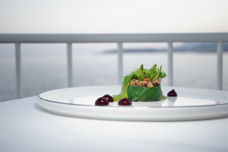 Cappon magro vegetale. «Abbiamo ripreso una ricetta della tradizione ligure», normalmente è una specie di millefoglie di verdure e pesce. In questo caso, invece, il vegetale è protagonista unico, niente pesce sostituito da "verdure marine" come la salicornia e la lattuga di mare (Ulva lactuca, un'alga). Sopra un biscotto di riso, che ricorda la classica galletta del marinaio che di solito si trova alla base del piatto. Poi crema di barbabietola e classica salsa verde del cappon magro (ossia prezzemolo, basilico, pinoli e aceto). Piatto semplicemente straordinario