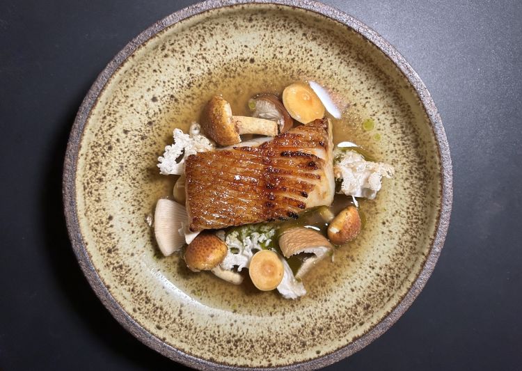 Scorfano rosso alla griglia, funghi corallo e pioppini, brodo aromatico, olio di kombu tostato: «Lo cuociamo sul carbone e lo spennelliamo con una glassa appiccicosa ai peperoncini. Abbiamo messo in salamoia molti peperoncini habanada durante l’estate, ne riduciamo il liquido di conserva fino a ottenere questa glassa. Ci sono poi funghi cinnamon cap, pioppini, enoki e funghi corallo. Infine un brodo realizzato con lische arrostite del pesce, funghi shiitake e alga kombu». Un piatto perfettamente definito