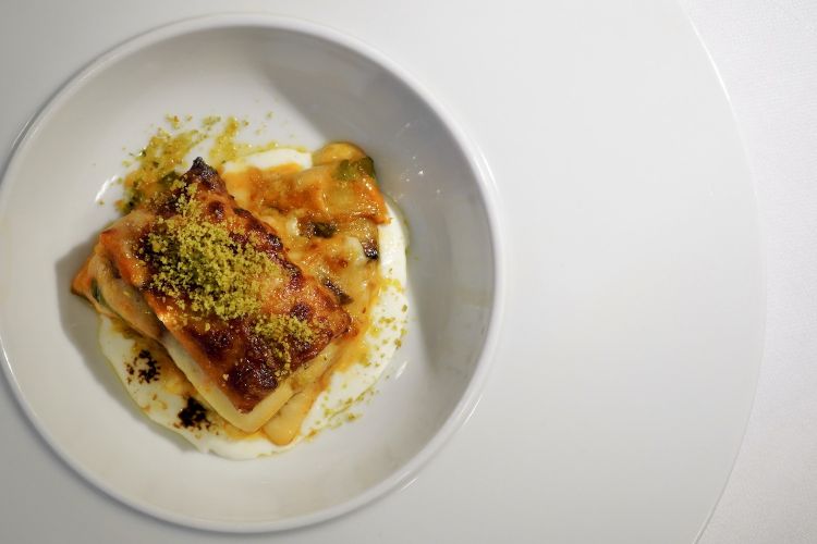 Altro assaggio di grande piacere, Parmigiana di melanzane, mozzarella bruciata e basilico. È di base una parmigiana classica, che richiama le origini dello chef, con cinque strati di melanzane fritte con farina di riso. Poi bufala, basilico, Parmigiano Reggiano, crumble al basilico e salsa di bufala. Che dire?