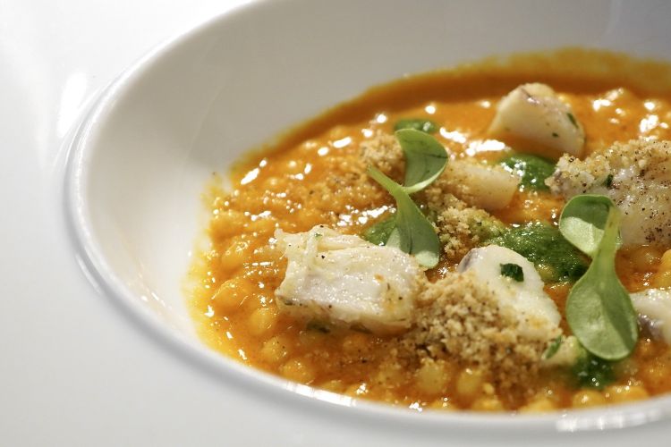 Fregola al sugo di pesci di scoglio (triglia, gallinella, scorfano, tracina), guanciotte di rana pescatrice al prezzemolo e crumble al pepe nero.