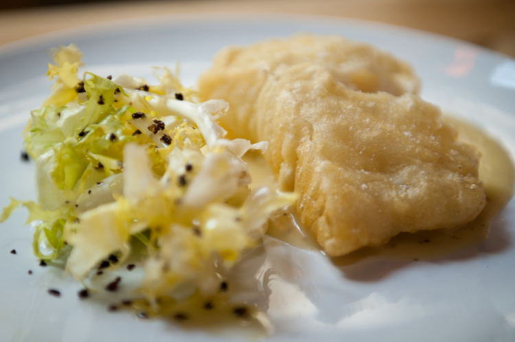 Filetto di baccalà islandese in pastella su crema di patate al limone, scarola riccia e olive itrane disidratate