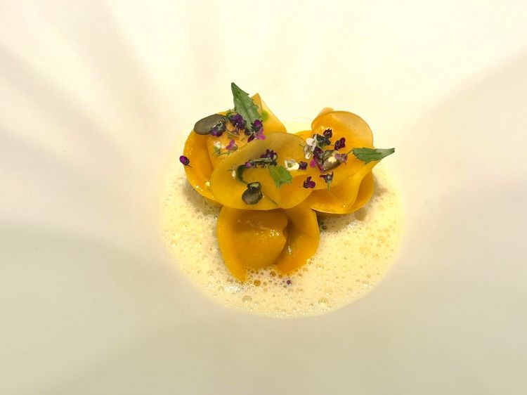 Zucca, un piatto elegante e deciso: tortelloni ripieni di zucca, i suoi semi glassati con tamari, salsa di Koji lattofermentato e pesto di tagete
