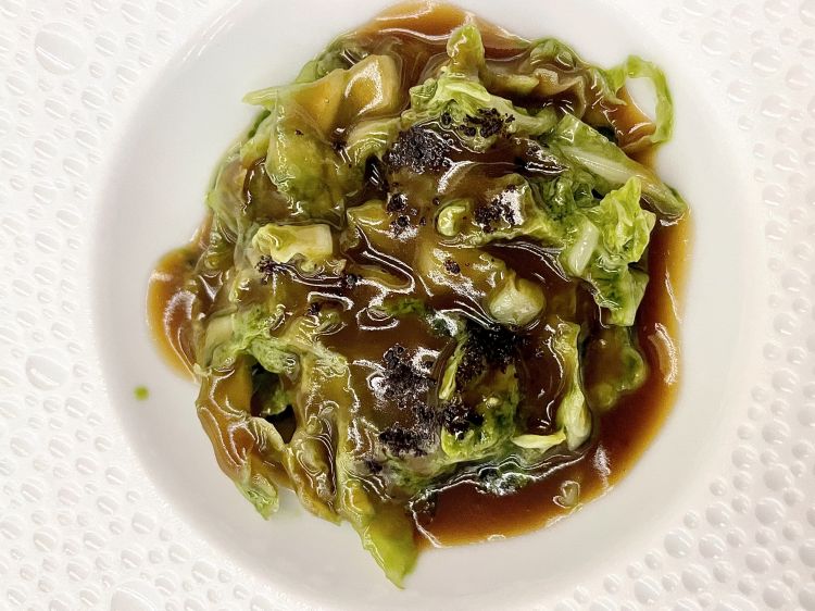 Verza e cinghiale
Verza fermentata, cotta in un succo di verza ridotto, servita con una salsa di cinghiale e fagioli; questi ultimi sono presenti anche in cima, sotto forma di polvere di miso realizzata con gli scarti dei fagioli. Emerge la parte grassa del cinghiale, il suo collagene, e anche la callosità di questa carne che ha pari spazio sul palato, del fagiolo, un velluto