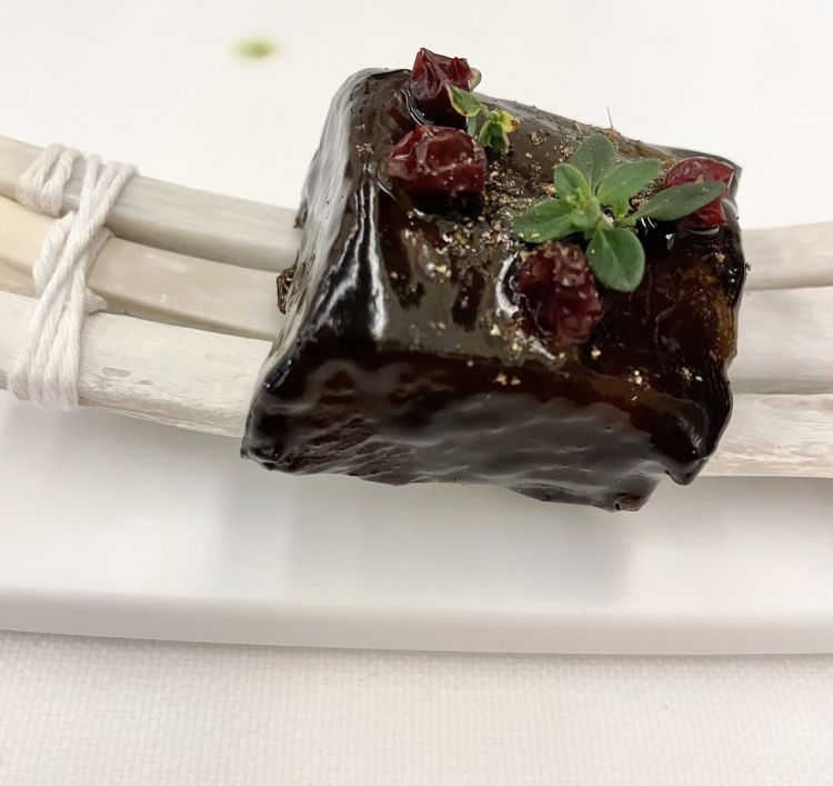 Costina di cervo cotta al bbq servita con frutti rossi e timo. C'è una spezia intensa, il ginepro che dà ulteriore forza alla carne, da mangiare con le mani, a morsi. Sfilacciosa, sanguigna