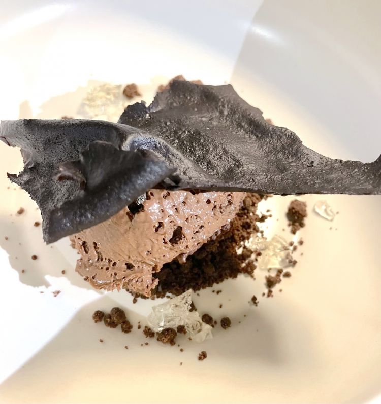 Sospiro a Frascati
Il sospiro a Frascati è un po' come l'ombra a Venezia, un momento di pausa, ma anche una scusa per bersi un bicchiere di vino, 120 ml. Un momento di piacere. Così come lo è il dessert che fa 120 g, composto da 4 tipologie di cioccolati, come 4 sono le stratificazioni delle ere geologiche nella grotta. Alla base, ganache al cioccolato bianco, terra salata, mousse di cioccolato affinato in grotta, persistente e, in cima una tuille, con gel di malvasia puntinata