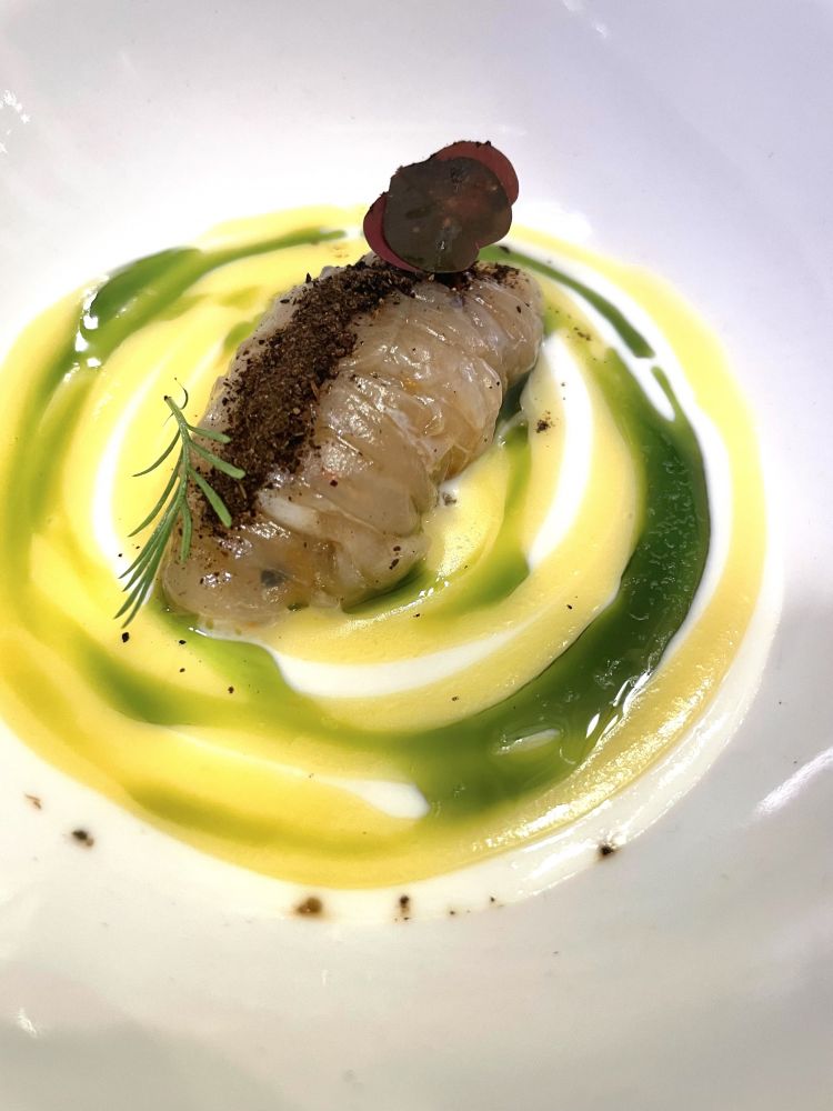 Tagliatella di seppia, bufala, limone, capperi e scichimi
Una linguina al burro e limone: è questa l'impressione gustativa che riceviamo socchiudendo gli occhi; è al dente, ma non è pasta, bensì una seppia, tenace in masticazione; viene condita con crema di bufala, spumosa, e limone; una polvere di capperi che si lega al scichimi, miscela di spezie giapponese composta da almeno sette ingredienti
