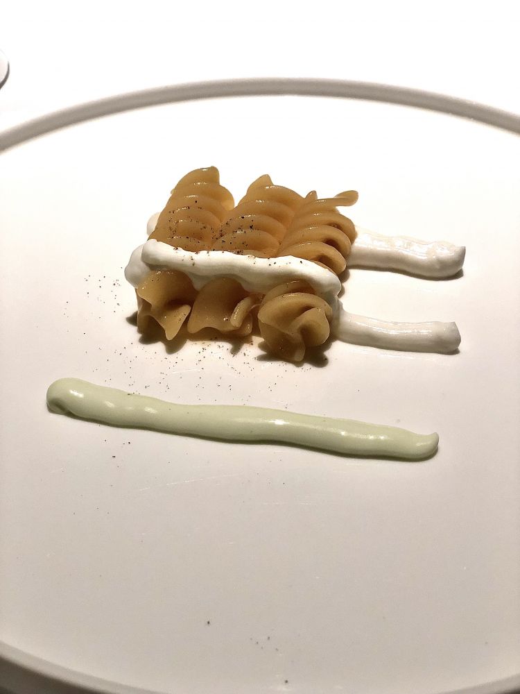 Pasta in bianco, al dente: il bianco è la crema di Parmigiano Reggiano, da alternare di morso in morso alla crema all’alloro, intingendo direttamente il fusillo “nudo”
