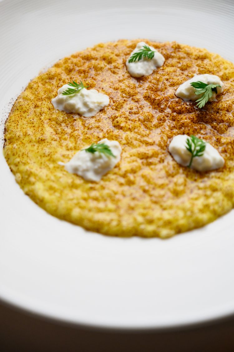 Risotto, limone, burrata e liquirizia
Il Garda e i suoi limoni: Bufi, superando la sola tendenza di farne del limoncello, accoglie quest'agrume nella sua cucina; lo cuoce a bassa temperatura - polpa e buccia insieme - con dello zucchero, per poi introdurlo in questo risotto che mantiene piacevoli sensazioni di acidità, mitigate di volta in volta dalla carezza balsamica della liquirizia e da tutta quella fresca grassezza della burrata