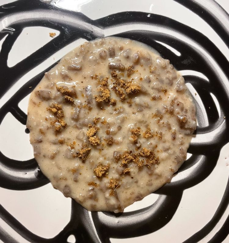 Riso di pane vecchio, un piatto di recupero assoluto.
Il pane avanzato viene ridotto in briciole, tostato, quindi risottato nel siero di latte di capra fermentato 20 giorni fino a cottura; il finto riso assorbe parte del siero, ma non si sfalda. In cima, bottarga... o meglio la sua versione di recupero perchè in realtà parliamo di lische essiccate. Il sapore è ben definito, le consistenze rispettate (probabilmente bisogna lavorare ulteriormente sulla consistenza del pane per rendere ancora più interessante la masticazione); si alternano sul palato la piacevole acidità del siero, che stimola la salivazione, e una spinta marina, iodata della finta bottarga