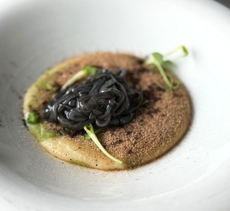 Calamari preparati crudi all’interno di un’arancia bruciata e conditi con riduzione di fumetto, vino bianco, nero di seppia e lemongrass, serviti su crema di patate e lardo, piselli in due consistenze, polvere di pane e limone nero. Questo è sicuramente il piatto che abbiamo apprezzato di più in quanto tutti gli ingredienti si sposano perfettamente nell'insieme, rendendo il piatto bilanciato e armonioso. Recepiamo la sapidità del nero di seppia che si controbilancia con la freschezza e l’acidità del lemongrass e del limone nero. Completa il piatto la dolcezza e delicatezza della crema di patate. L’elemento principale del piatto, ossia il calamaro crudo ha una consistenza perfetta e si scioglie quasi in bocca. Chapeau!