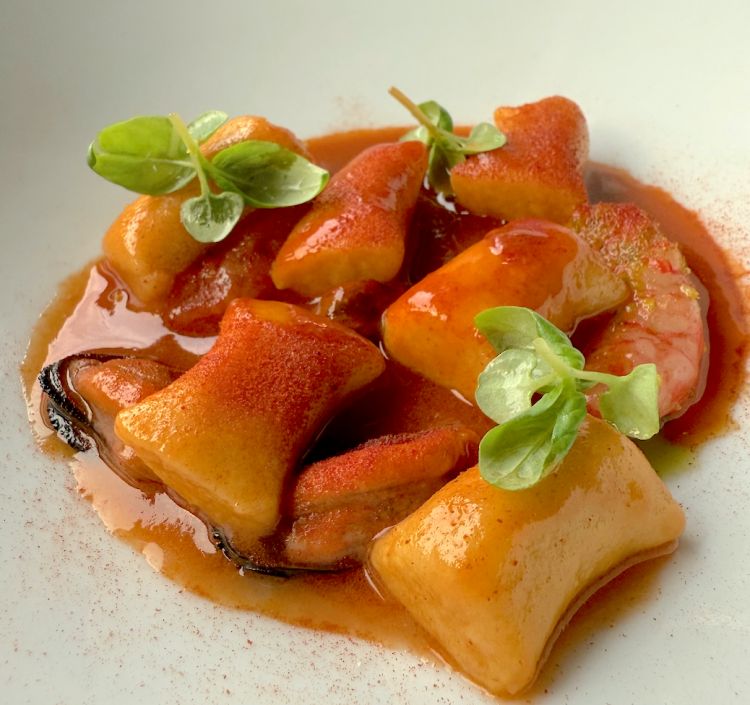 Gnocchi di patate, cozze, gamberi rossi e cacciucco. Gli gnocchi sono fatti in casa e vengono esaltati dal sapore molto intenso del cacciucco che si controbilancia con la dolcezza dei gamberi rossi e con la sapidità delle cozze. Anche in questo caso un altro piccolo azzardo da parte di Alfredo, ossia abbinare un piatto di pesce, molluschi e crostacei a un rosso servito molto freddo, ossia un Lagrein Riserva Urban Tramin 2021