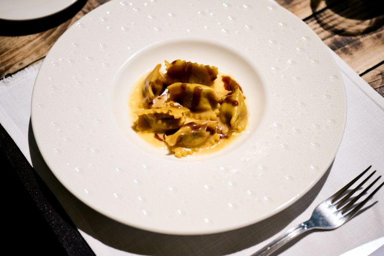 Non solo pesce, ma anche primi carnivori vista mare, come i Ravioli al plin ripieni di Rosticciana, burro nocciola e Parmigiano Reggiano di montagna 30 mesi