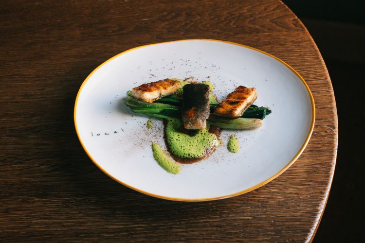 Anguilla, cicoria e tamarindo: un po’ Venezia, un po’ Napoli. L'anguilla viene maturata in cella frigo per una settimana, cotta a bassa temperatura e poi passata alla griglia per ottenere una pelle molto croccante. La nota amara è conferita dalla salsa teriaky al lapsang, ma anche dalla cicoria saltata con caffè; infine, il tamarido apporta una spinta super acida bilanciando la grassezza dell’anguilla