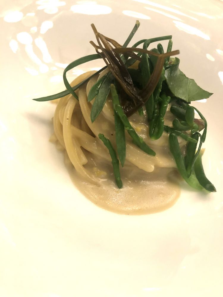 Spago del Mare
Spaghetti, burro di acciuga, mou d’uovo ed erbe del mare

In un piatto si condensano tre immagini: la pasta di acciughe, amara e salina del burro; la vegetazione del mar Mediterraneo con salicornia e finocchietto. Poi, in questo quadro marino, irrompe l’uovo, con delicatezza, rotondo, portando in tavola quella che è una carbonara di mare 2.0: grassezza, dolcezza e sapidità, in un'unica portata
