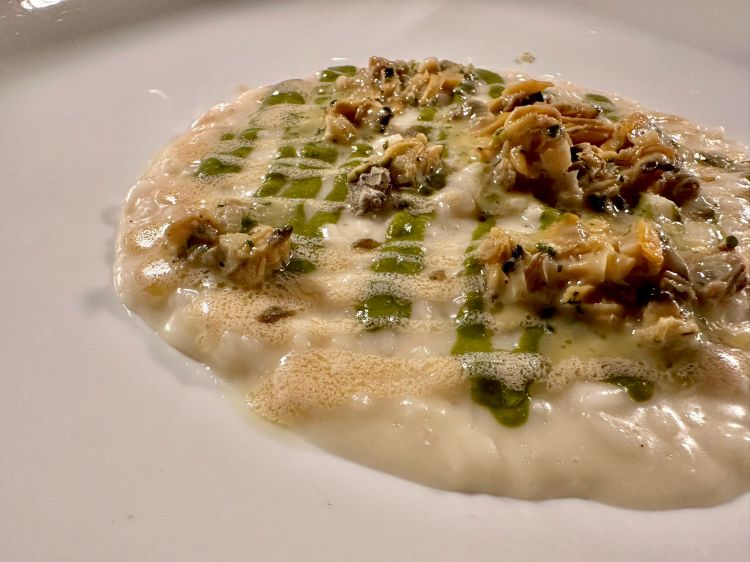 Riso carnaroli al Vermentino, vongole alla bourguignonne, capperi e gel al prezzemolo
Un risotto setoso che ci porta in riva al mare, al fondo della padella di un sauté, dove si concentrano prezzemolo, aglio e lo iodio della vongola che, piccola, carnosa, presente, muove in un intreccio di prezzemolo in gel e una ricca mantecatura al Vermentino, tale da sprigionare un'acidità aromatica, avvolgente per svelare lentamente il cappero. In abbinamento, Galesa, Valli di Porto Pino IGT 2020, un "bianco fatto come un rosso", intenso, ampio. In questo caso, Vermentino in purezza, colore paglierino e un naso di mango e frutti esotici; al palato, luce mediterranea e i sentori della macchia, mentre sul finale una sapidità che non abbandona mai il sorso