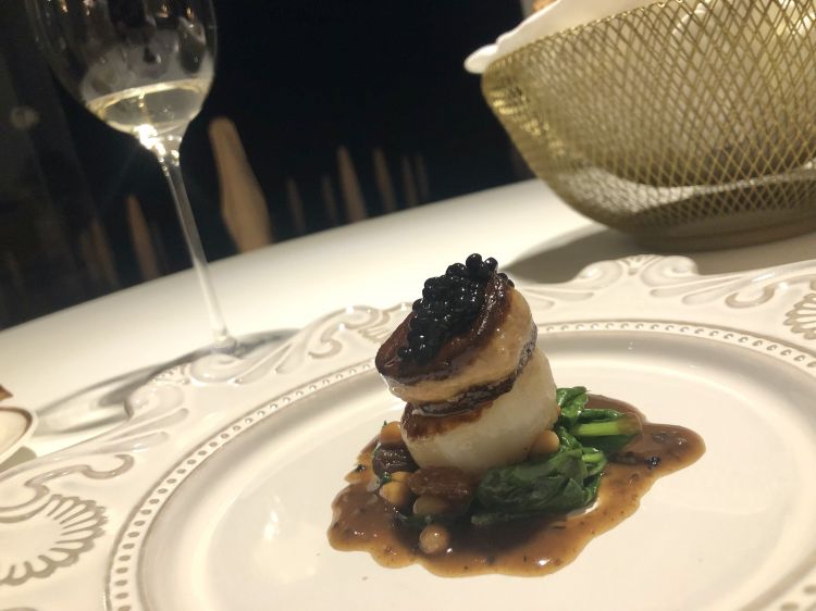 Capasanta alla Rossini
Carnosa la capasanta, in cima al foie gras è stato aggiunto un perlage di tartufo nero che accentua il gusto rotondo del piatto, senza mai risultare pesante merito della scarola saltata con uvetta e pinoli, contorno sfizioso dal profondo Sud

