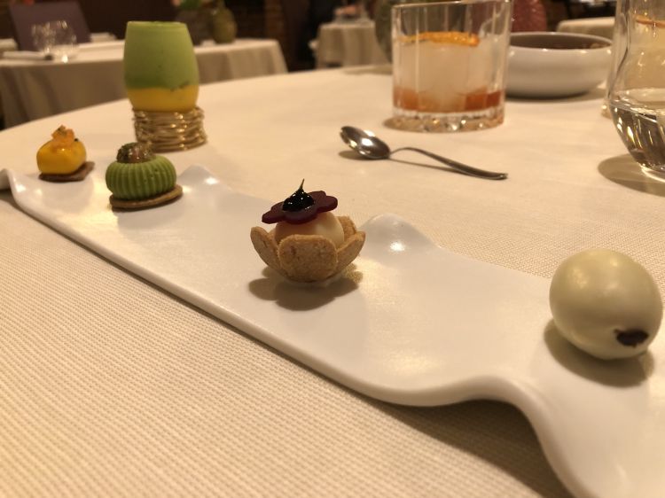 Le entrées della nostra cena a Opera: da sinistra, spuma di piselli con ananas alla brace e tuorlo; assoluto di carota; zucchine in scapece e uova di trota; tartelletta al Parmigiano Reggiano; bon bon all’oliva taggiasca e cioccolato bianco