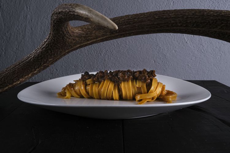 Tagliatelle al rag&ugrave; di cervo adulto:&nbsp;carni&nbsp;di collo e spalle, in parte macinate, in parte - la maggiore - battute&nbsp;al coltello; vengono poi arrostite&nbsp;a parte e unite&nbsp;a verdure arrostite, cotte insieme con il calore dolce della cucina economica; si sfuma&nbsp;con un po&rsquo; di vino fino a ottenere una specie di rag&ugrave; non cotto per ore e ore, ma arrostito per 3 ore circa per farlo asciugare alla perfezione e imbrunire, in modo da sprigionare la forza e il vigore di questa carne straordinaria
