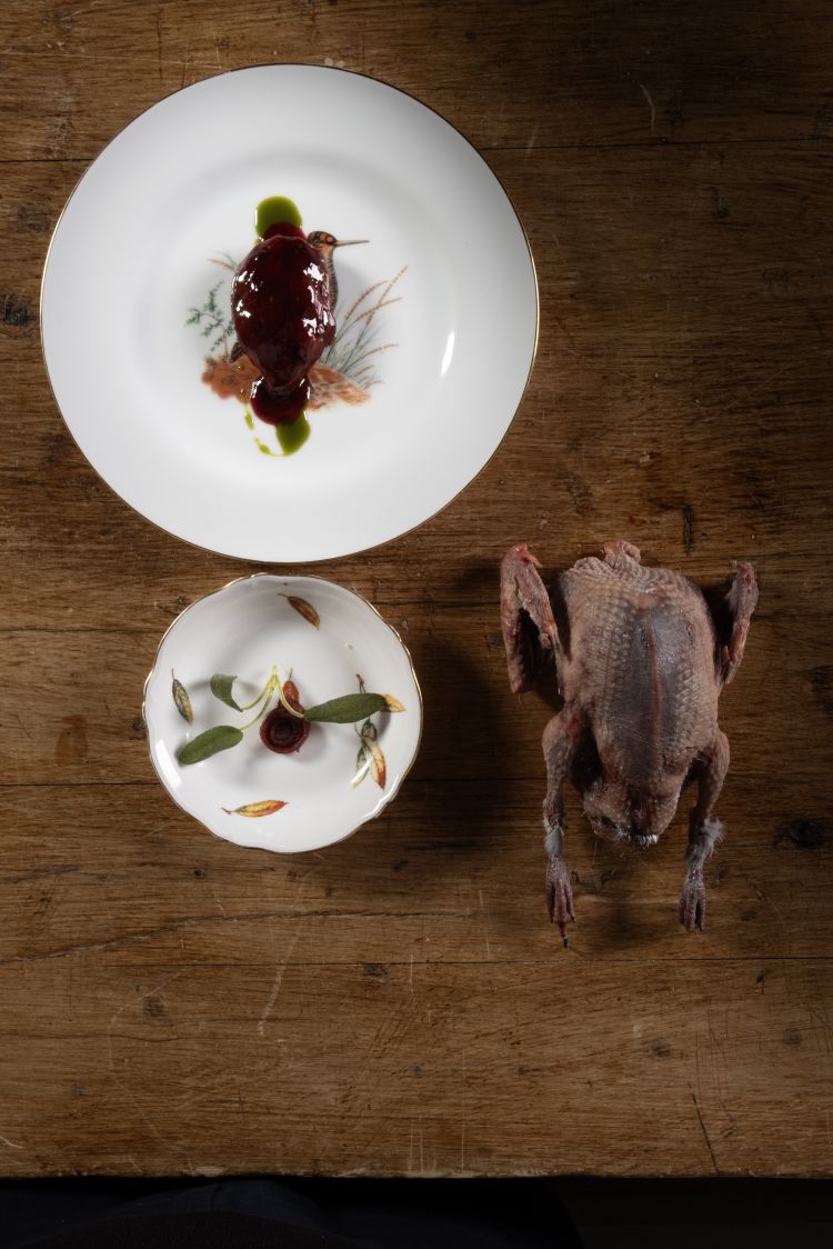 Colombaccio: filetto marinato per pochi secondi nel suo garum, appena scottato su una griglia piccola&nbsp;al tavolo. Nel piatto,&nbsp;il petto, cotto come una tagliata, al sangue,&nbsp;il condimento a base di sugo di fichi secchi, cipolle e stomaco del colombaccio. Nella parte alta del piatto, un cubetto di petto cotto a lungo in modo da sprigionare le note intense, ferrose, ematiche e anche la consistenza di un fegato
