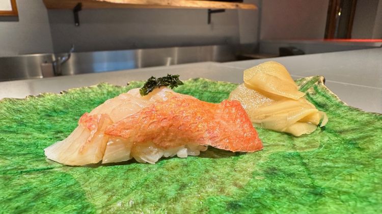 E ora, la sequenza di nigiri degustati nel corso della nostra cena.

Primo assaggio, Kinmedai: berice rosso
Il Kinmedai, molto popolare in Giappone, è un nigiri di berice rosso dal gusto delicato. La cottura e la temperatura del riso che accompagna il pesce sono perfette (36° C).

In abbinamento a questo e ai quattro nigiri successivi, ci viene proposto il sakè Akashi-Tai Daiginjo Genshu.
