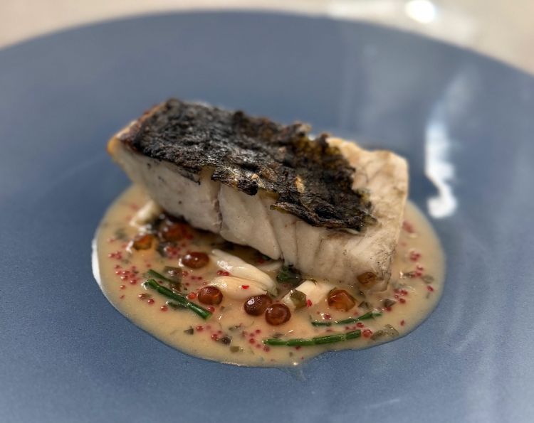 Si prosegue con Rombo alla brace con alghe di mare, bergamotto e uova di lompo e salmone. Il rombo alla brace convince per precisione di cottura: carne tenera, pelle croccante. &Egrave; accompagnato da una salsa ottenuta dal fumetto delle lische arrostite e affumicate, con infusione di kombu, nori e katsuobushi, poi ridotta ed emulsionata al burro. Il bergamotto (scorza e succo), l&rsquo;alga wakame agrodolce, la salicornia, le uova di lompo e di salmone completano il piatto. Stratificato, iodato, con una bella profondit&agrave; umami.&nbsp;In abbinamento arriva un calice di Lugana DOC Riserva "S&ugrave;ere" Cantina C&agrave; Maiol 2021
