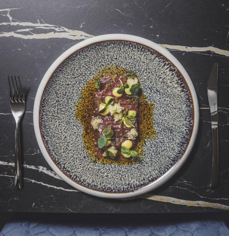 Tiradito di tonno, salsa al sesamo, soia e ostriche, tartare di mela, purea di avocado e maionese allo zenzero. Questo è uno dei piatti Must dello chef Baldo, un tiradito (sashimi) di tonno freschissimo condito con tartare di mela, purea di avocado, maionese allo zenzero e salsa al sesamo, soia e ostriche. Il tonno si scioglie in bocca e il piatto risulta armonioso grazie alla dolcezza dell’avocado che si controbilancia con la forza dello zenzero e l’acidità della mela. In abbinamento viene servito un calice di Sauvignon Blanc Hofstätter 2024.