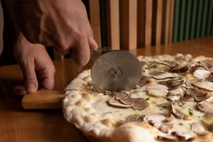 La pizza qui è sottile, estesa e segue la tradizione romana