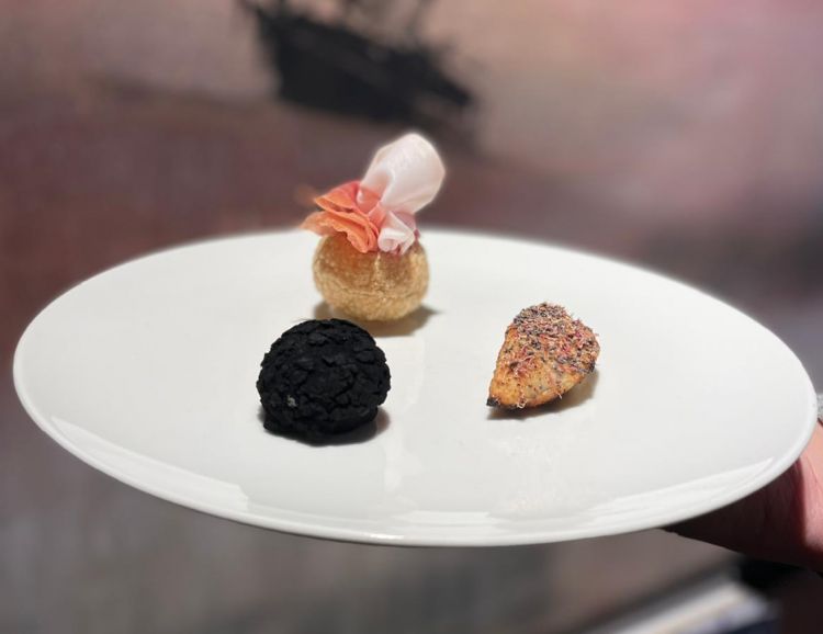Patrizia greatest snacks: dall'alto a sinistra, Gnocco o piada - Panipuri croccante, stracchino, pesto di rucola e prosciutto crudo; a destra, Lotofagi, un raviolo di pane azzimo alla brace ripieno di ricciola speziata, miele e semi e, in primo piano, Tartufi Cenerentola, un bignè craquelin al tartufo, crema di caprino affinato e marmellata di funghi. Ad accompagnare, il Patrizia to drink, un cocktail mix&stir a base di vermouth affinato nelle botti di aceto balsamico e nocino Riserva