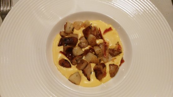 Padellata di capesante e porcini al ginepro su spuma di mais con bacon croccante, di Dionigi Colombo, chef del ristorante dell'Hotel Camana Veglia di Livigno
