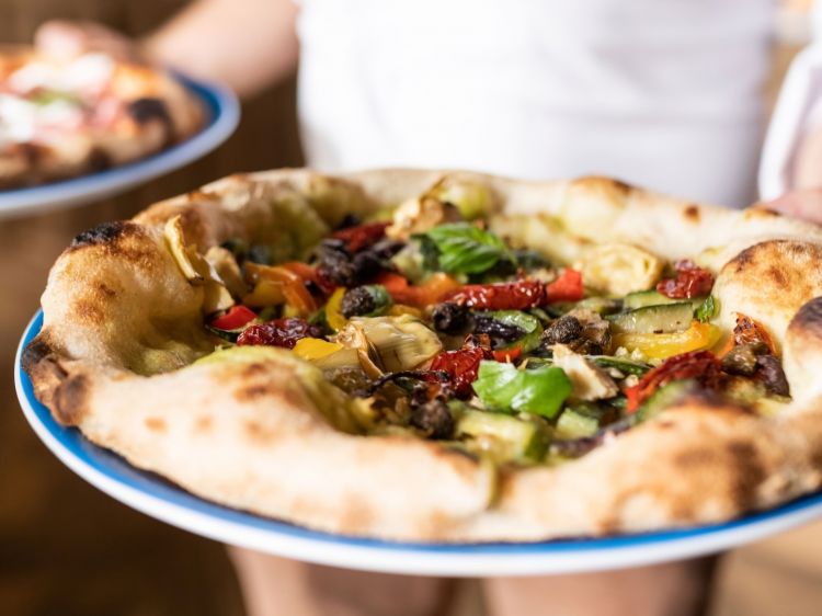 Pizza dall'orto di Fuocofarina, con crema di broccolo verde e verdure di stagione. Si può scegliere tra un impasto di biga di farina 0, farina ai 7 cereali e farina di farro oppure con impasto di sola farina farro steso al mattarello